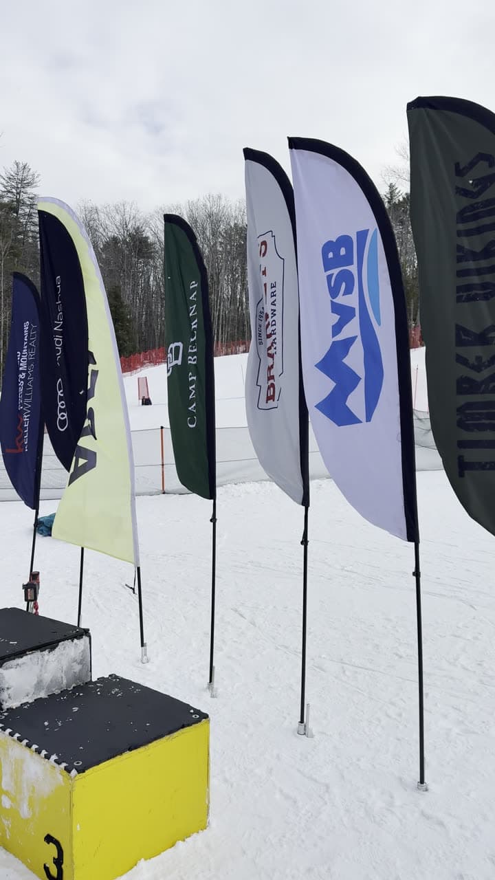 The sponsors' flags lined up beside the podium at the bottom of the hill on race day